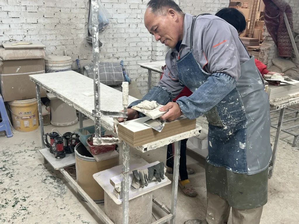Furniture factory worker checking cabinet panels and wiring components before assembly