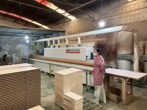 Furniture factory panel-processing area with stacked boards prepared for bedroom furniture production